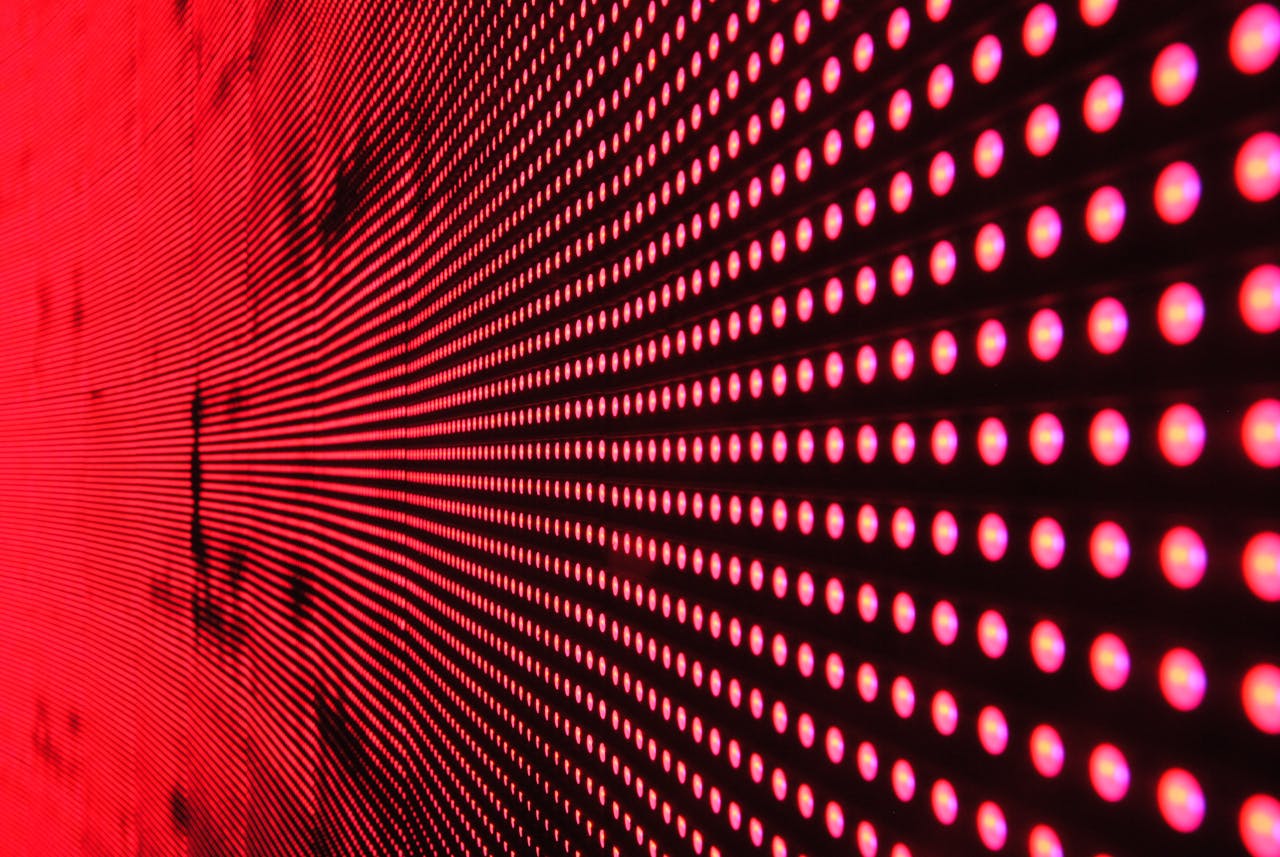 who-we-are Vibrant abstract pattern of illuminated red LED lights forming a dynamic design.